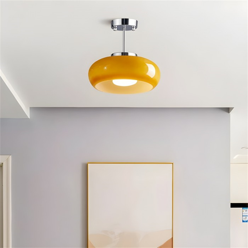 Vintage Bauhaus Deckenlampe aus Messing mit orangegelbem Glasschirm in einem Raum