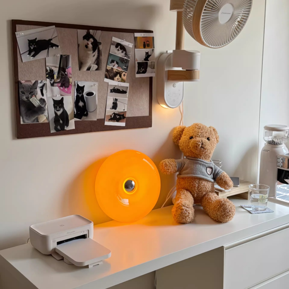 Kundenfoto der orangefarbenen Donut-Leuchte auf einem Schreibtisch