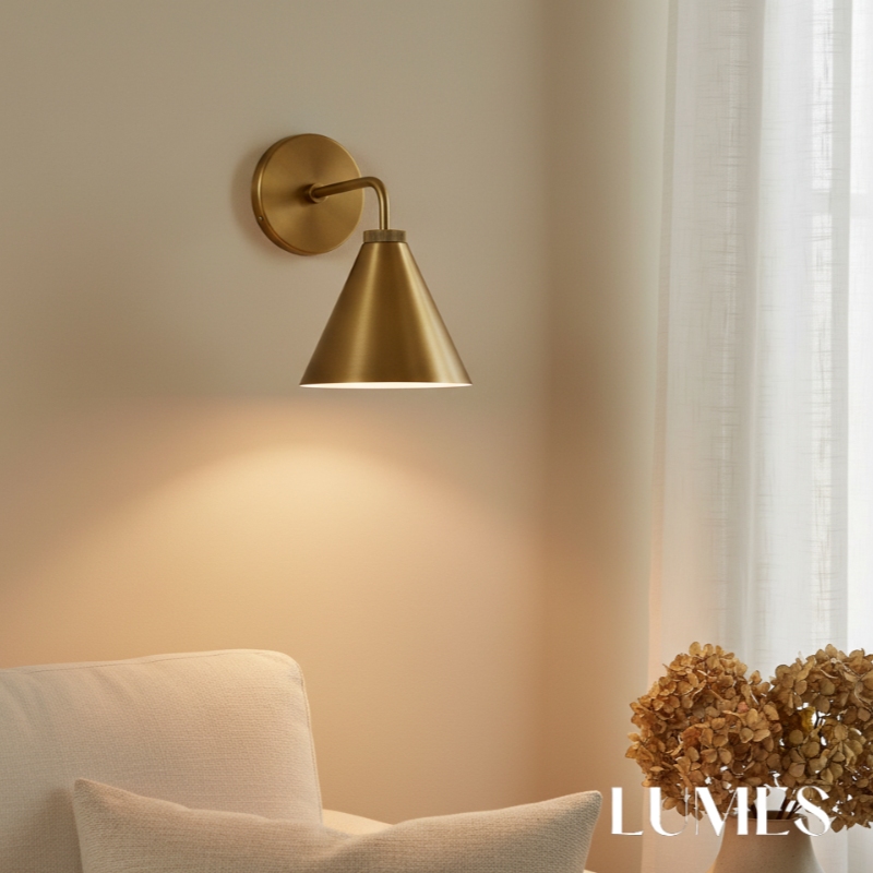 Korvi brass wall lamp glowing beside curtains