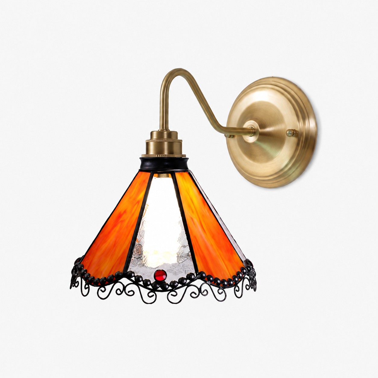 Orange stained glass wall sconce with antique brass-tone arm