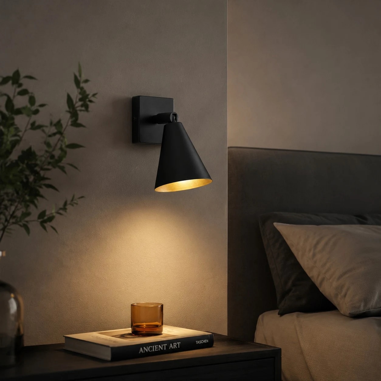 Black single-head adjustable wall lamp above a bedside table