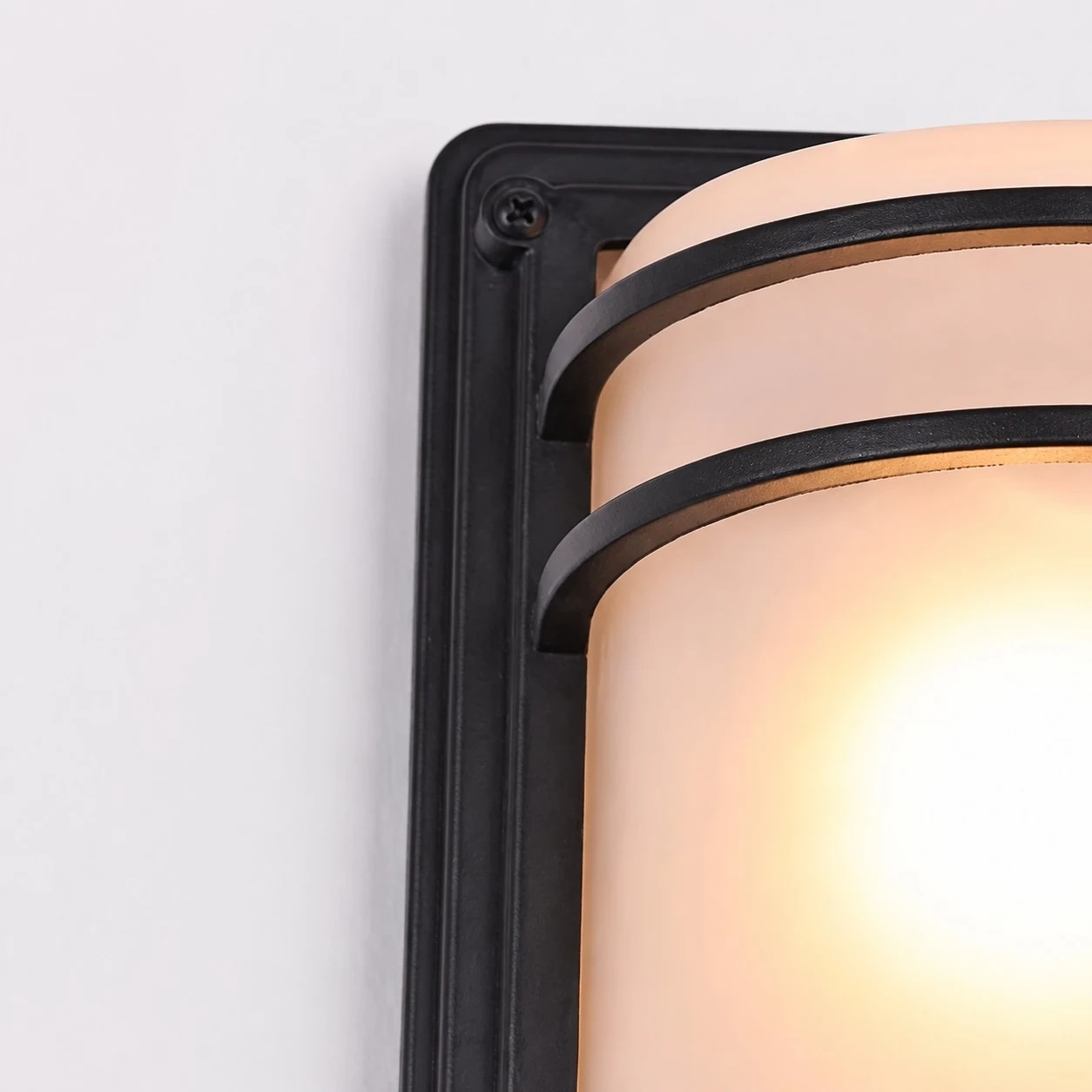 Close-up of screw, black base and curved glass shade