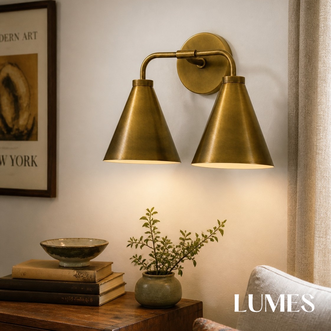 Dual head brass Korvi wall lamp above a side table