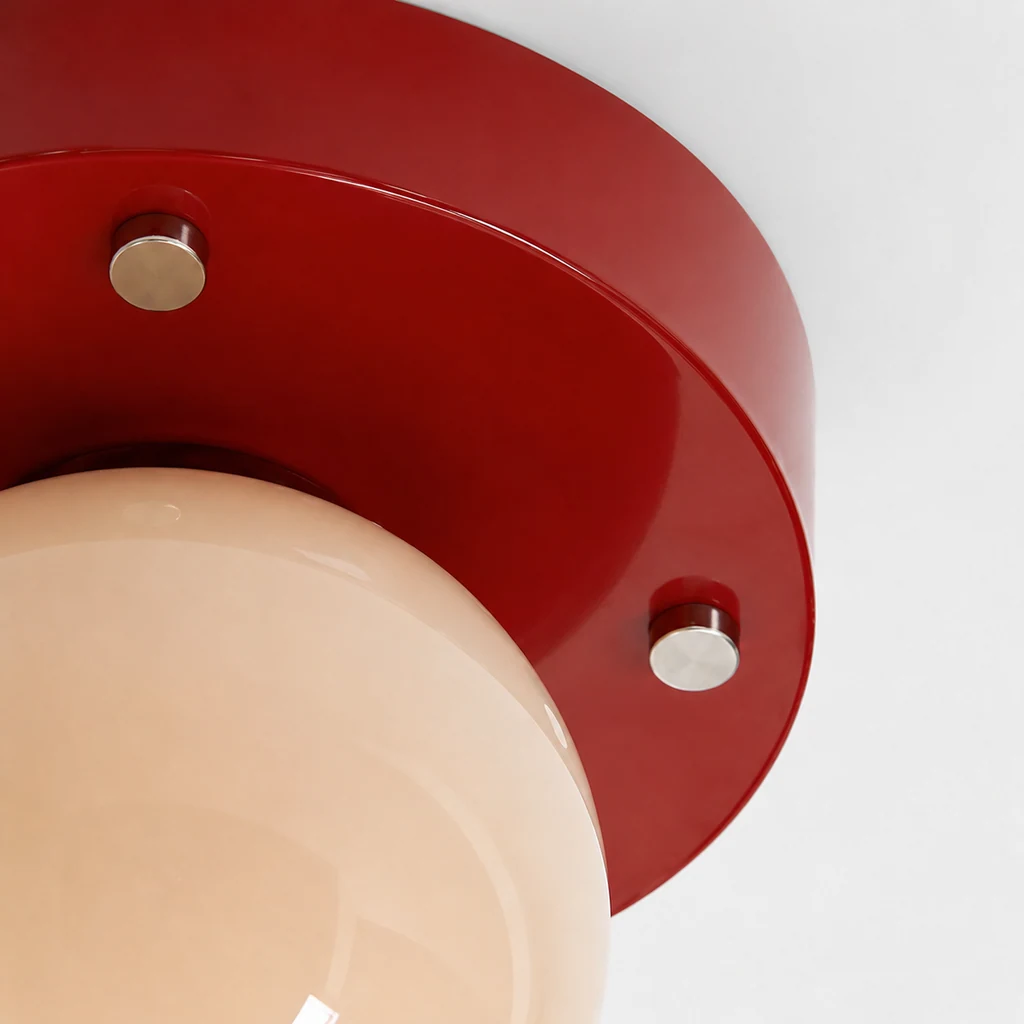 Close-up detail of red metal and cream glass on Memphis ceiling light