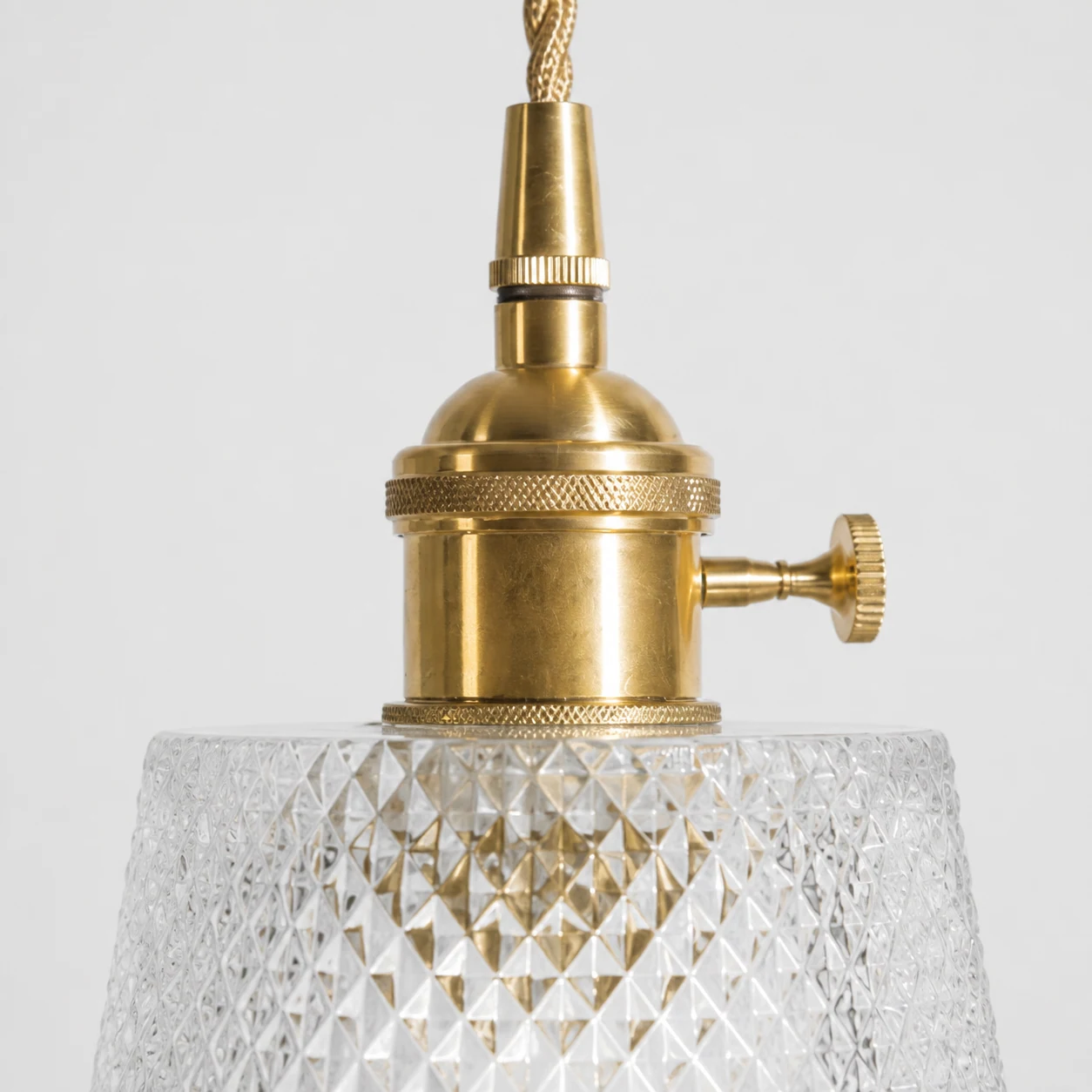 Close-up detail of brass hardware and textured glass shade