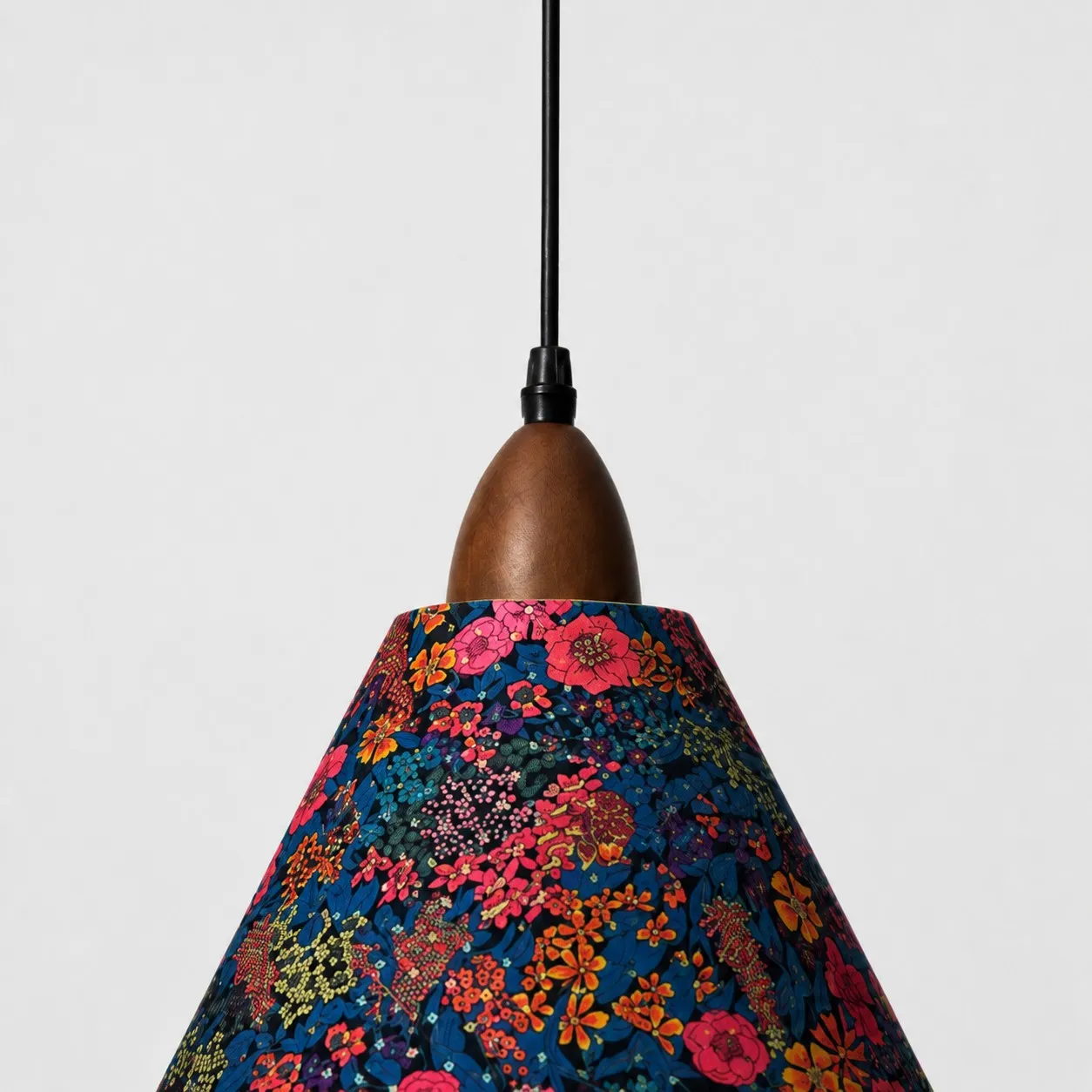 Close-up of walnut-tone wood holder and dark botanical Liberty fabric